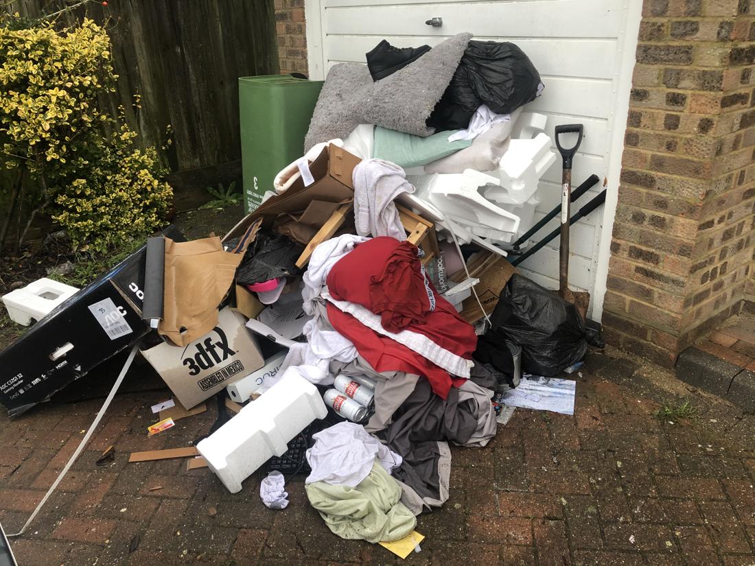 Driveway pile of household items and bags