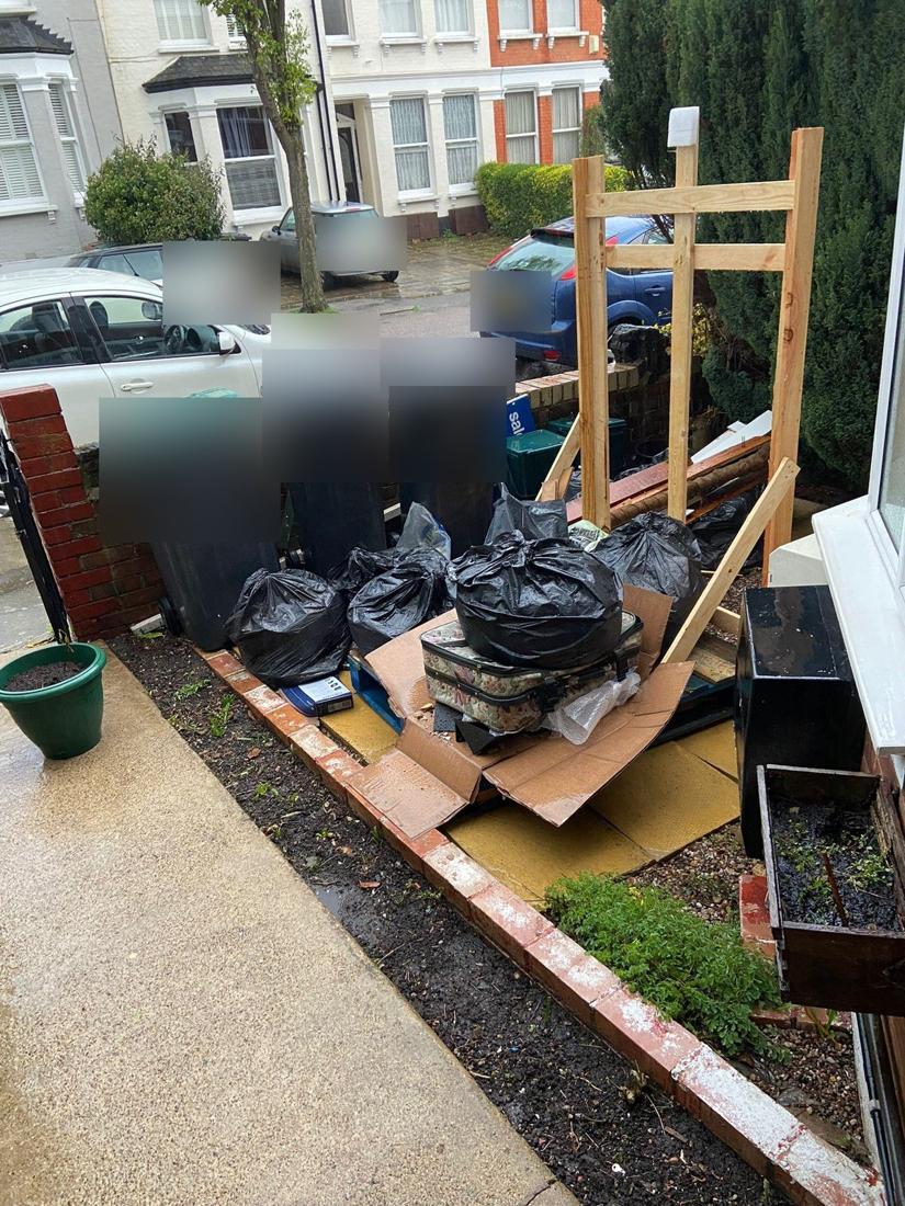 Front garden with bags and timber waiting for removal