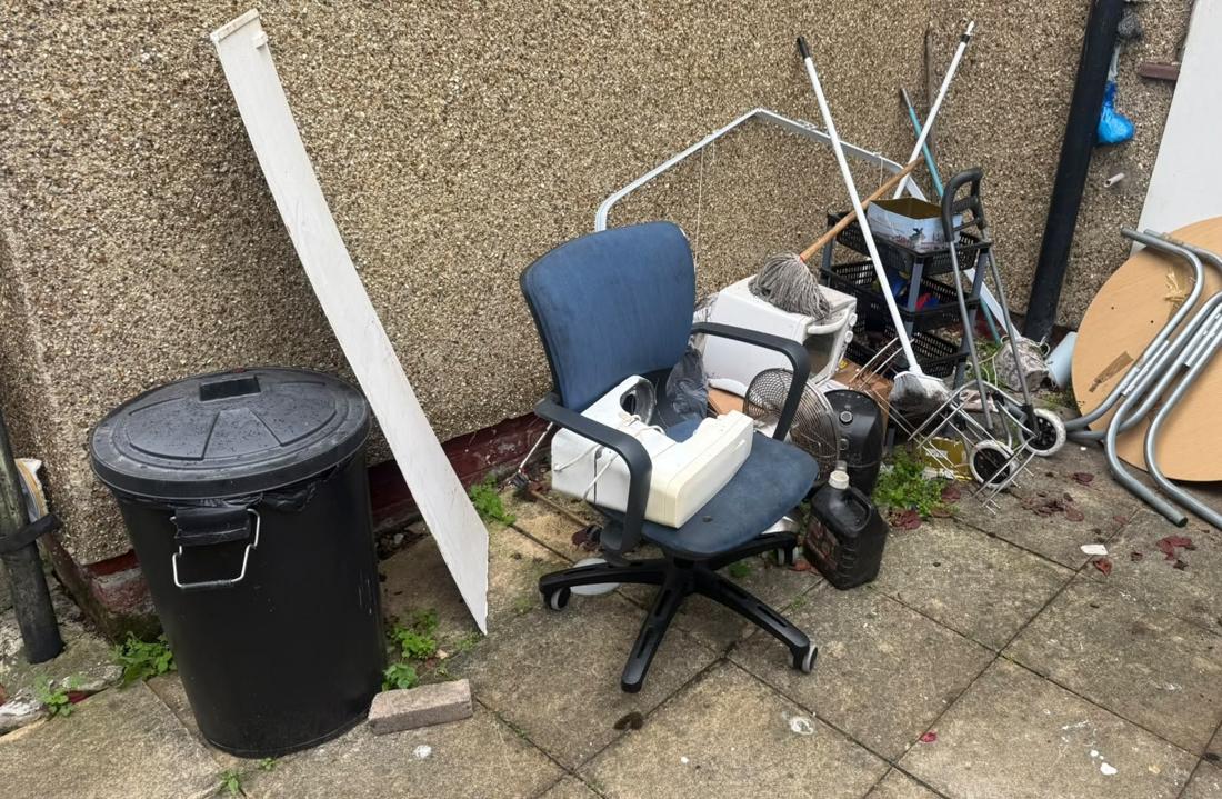 Patio with old office chair, bin and scrap metal
