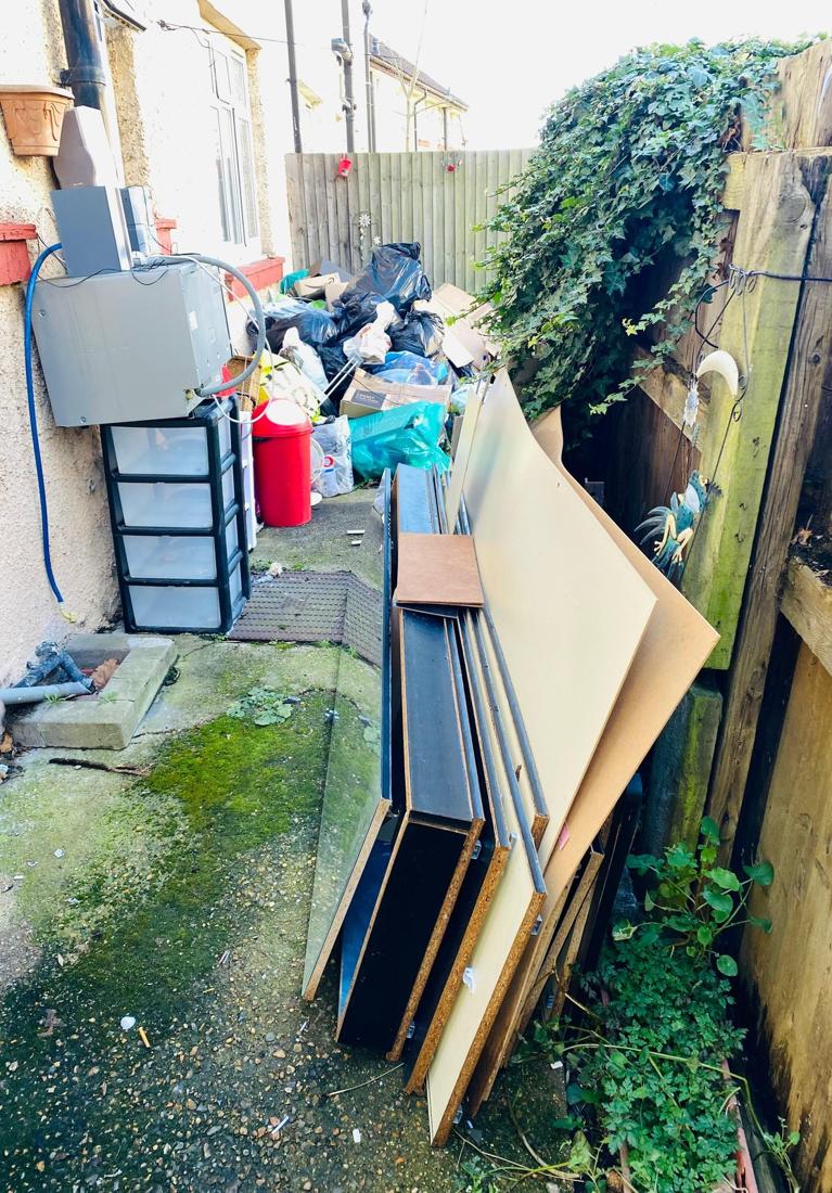 Side passage piled with boards, drawers and household junk