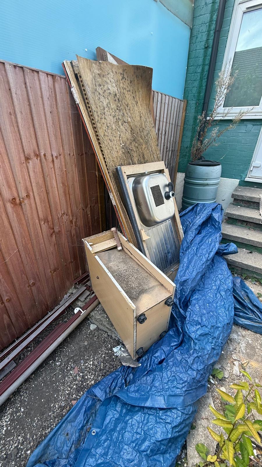 Bulky kitchen units and timber prepared for house clearance